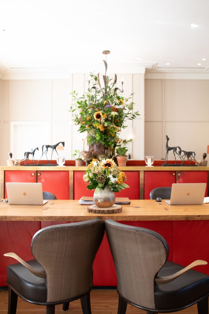 reception desk with flowers and two apple macbooks